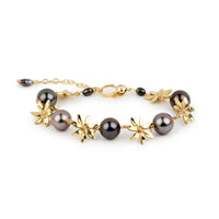 Gold bracelet with black pearls on a white background