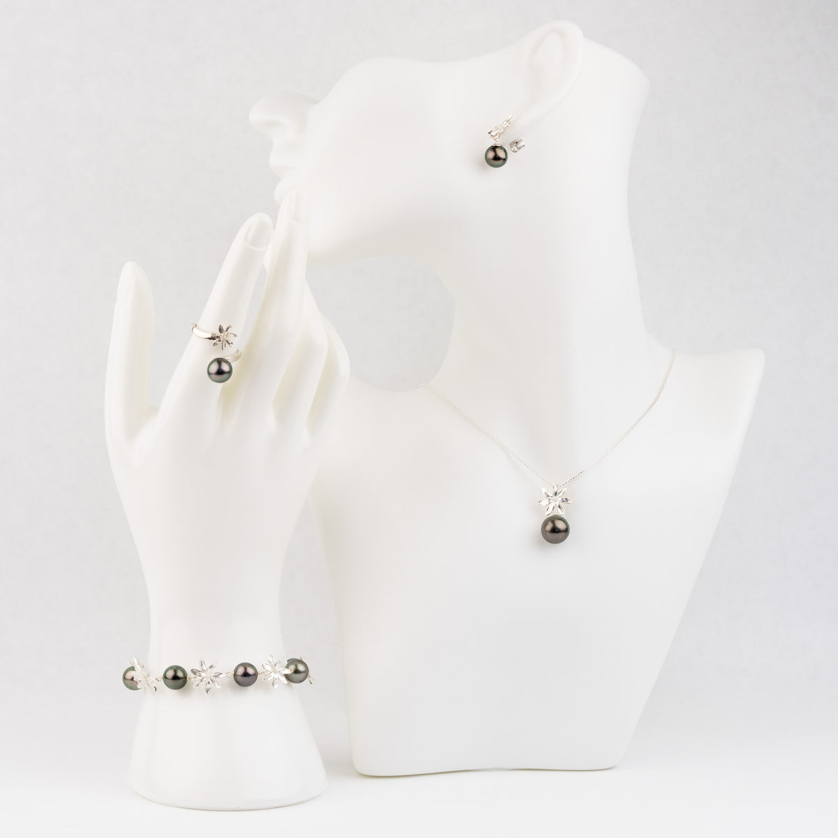 Necklace and earrings on a white mannequin bust against a white background