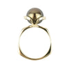 Gold ring with a large black pearl on a white background